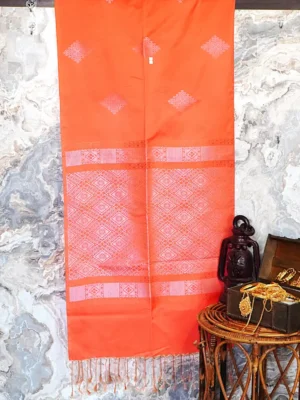 A bright coral orange semi-soft silk saree